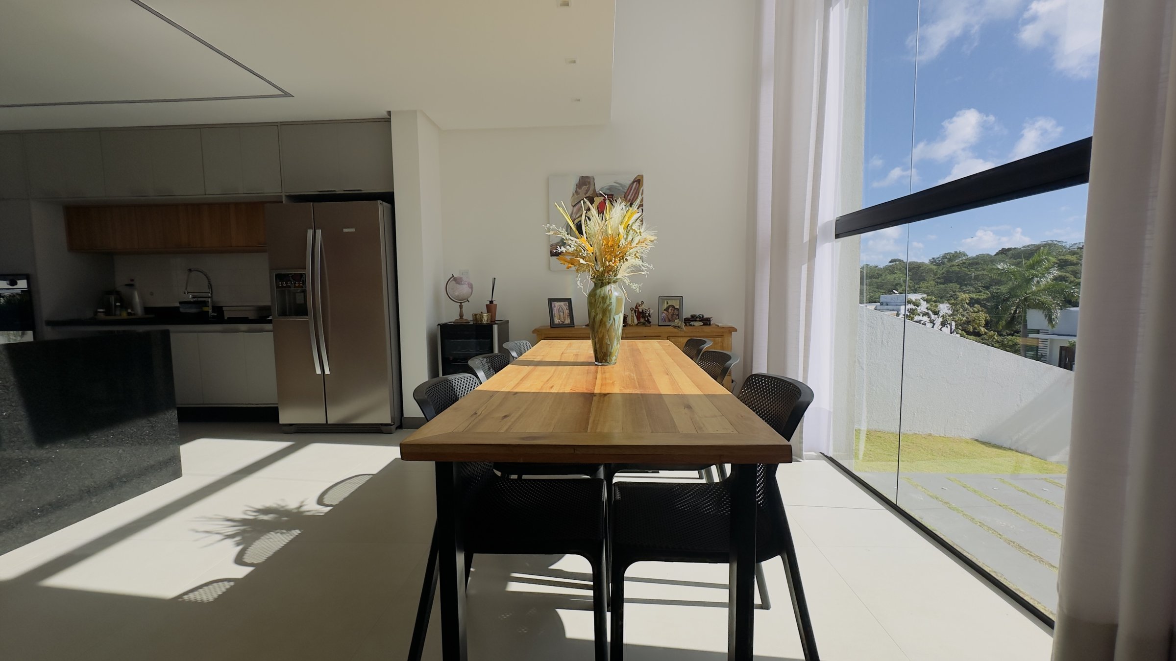 Mesa de jantar junto à fachada de vidro